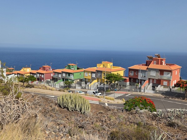 Hilera de casas de colores con tejados de teja y vistas al mar en Costanera