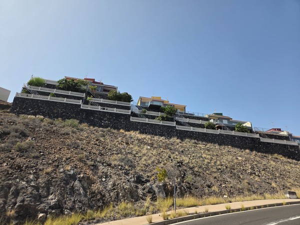 Viviendas en terrazas sobre muros de piedra volcánica en la ladera de Costanera