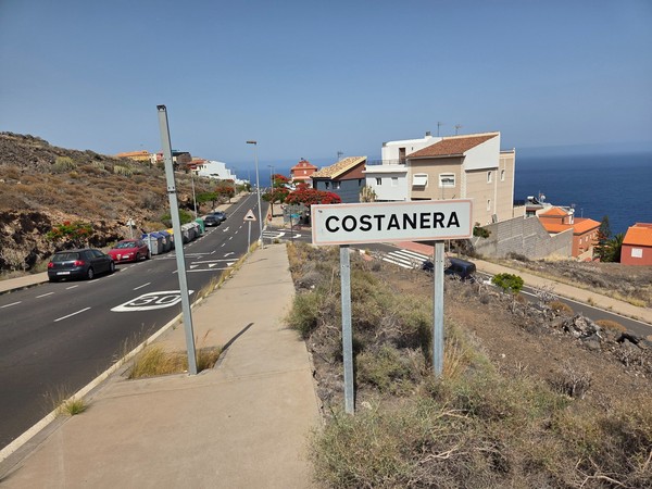 Cartel de entrada con la palabra Costanera frente al océano