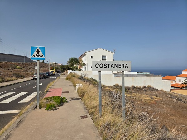 Señal de localidad Costanera junto a paso peatonal en la avenida