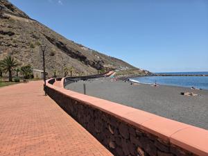 Paseo marítimo bordeando la Playa de la Nea Camino junto a la playa con vegetación
