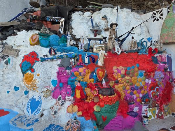 Pared decorada con murales y objetos reciclados